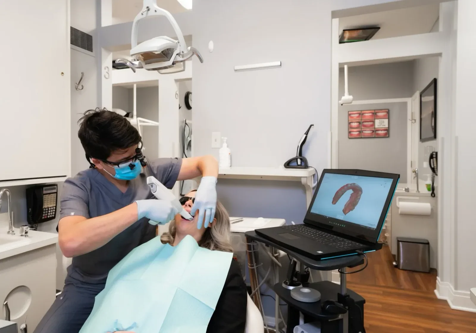 A Ross Dental clinician using an intraoral scanner while a digital scan appears on screen